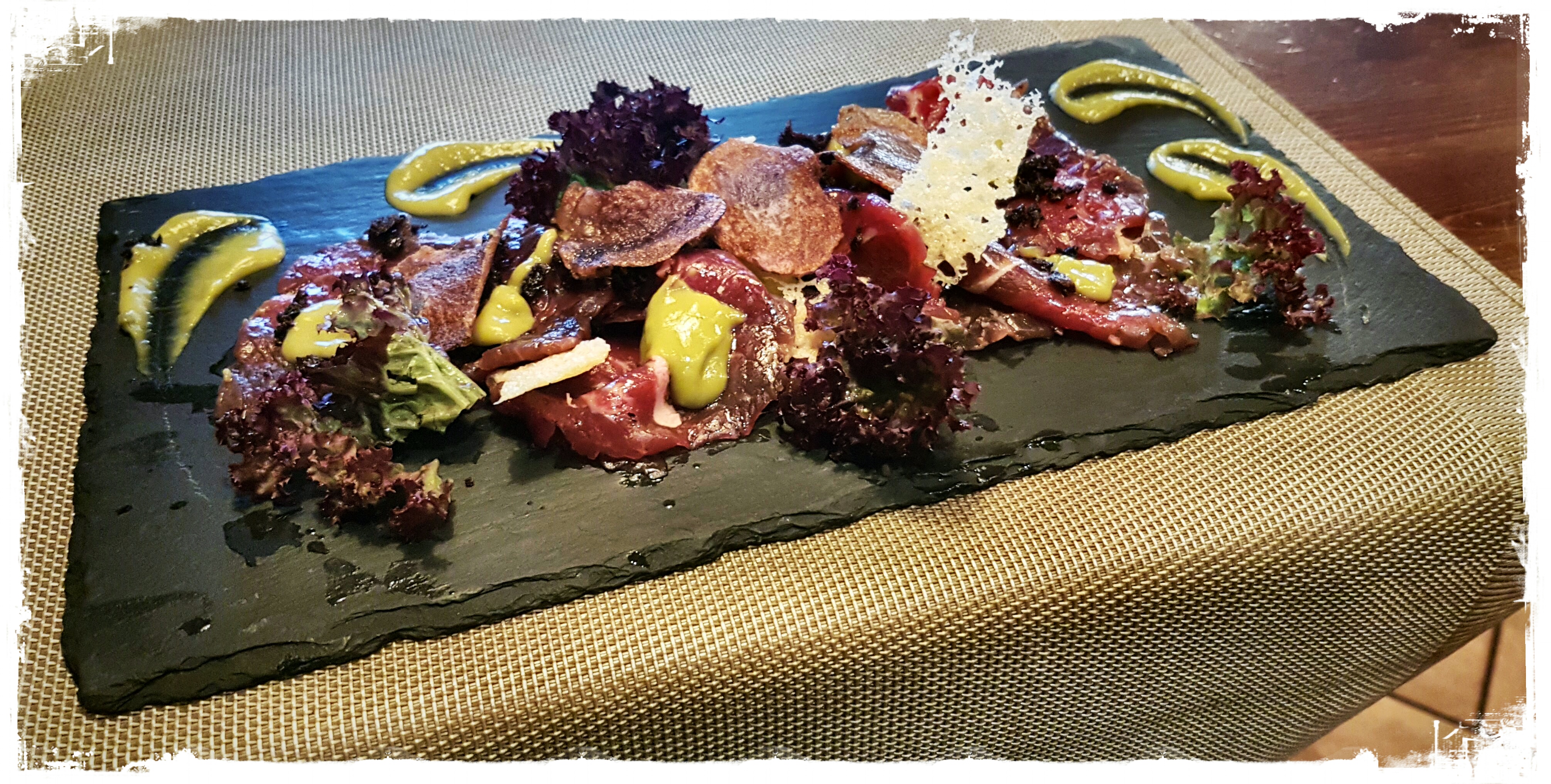 CARPACCIO DI MANZO Danese con crema di asparagi, crumble di olive taggiasche, croccante di parmigiano e chips di patate viola
